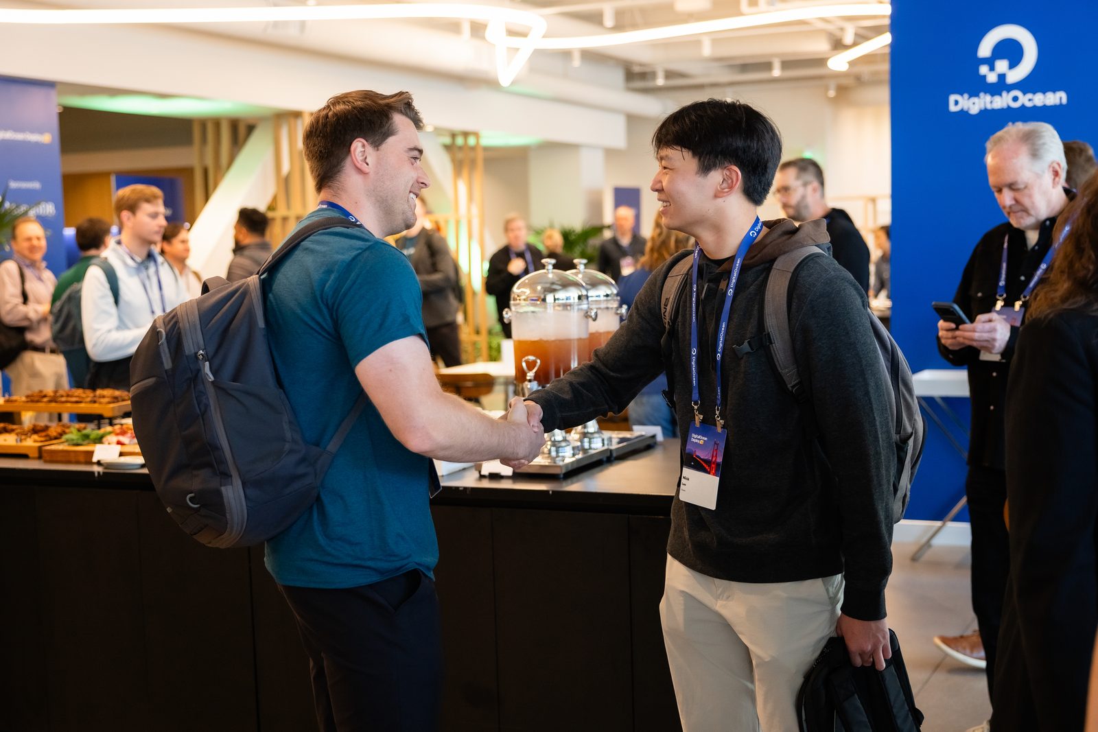 Two attendees shaking hands at a DigitalOcean event